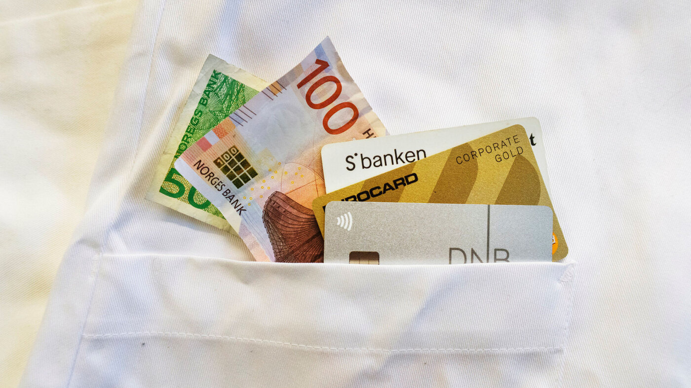 Penger og bankkort, i lommen på en sykepleieruniform