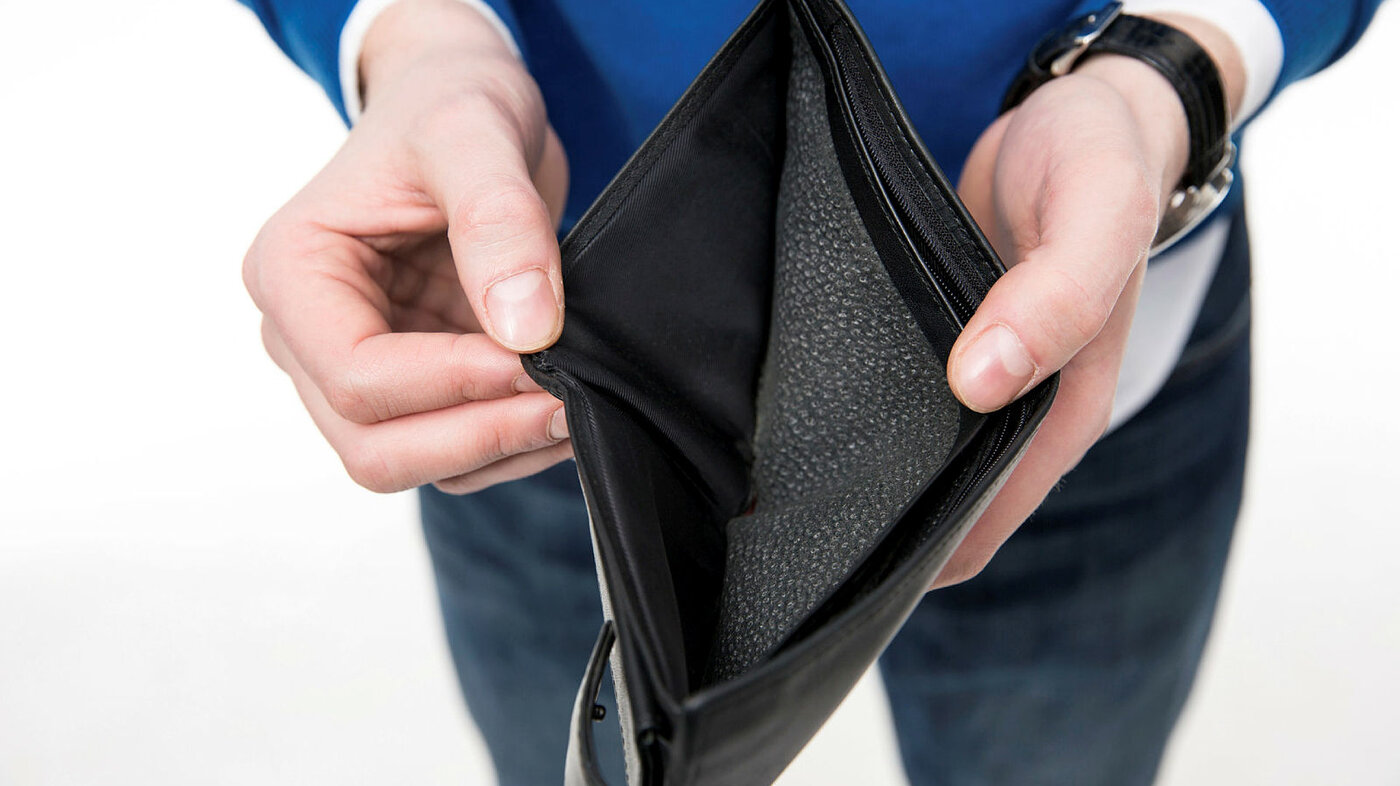 Bildet viser en person som holder frem en tom lommebok