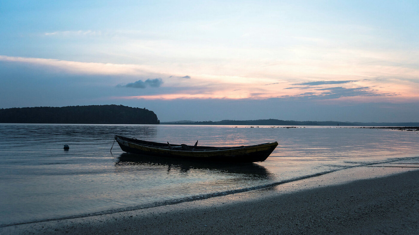 Båt Bildet viser en båt som ligger ved en strand om kvelden