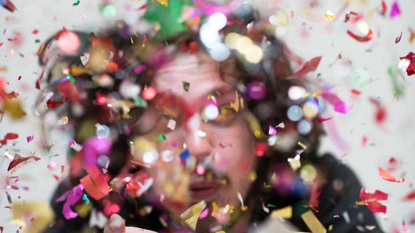 Feststemt person med confetti.