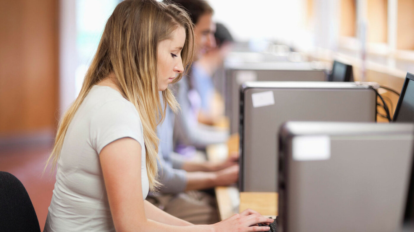 Bildet viser studenter som sitter foran PC-er på lesesalen.