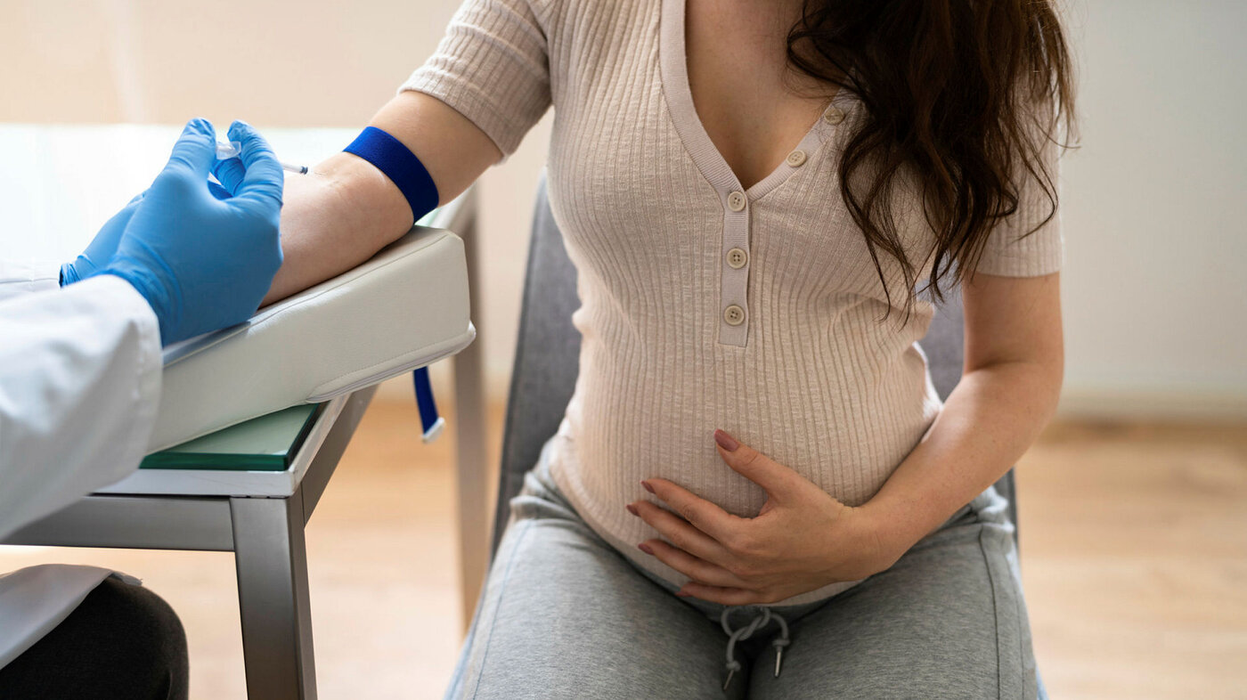 Bildet viser en gravid kvinne som blir tatt blodprøve av