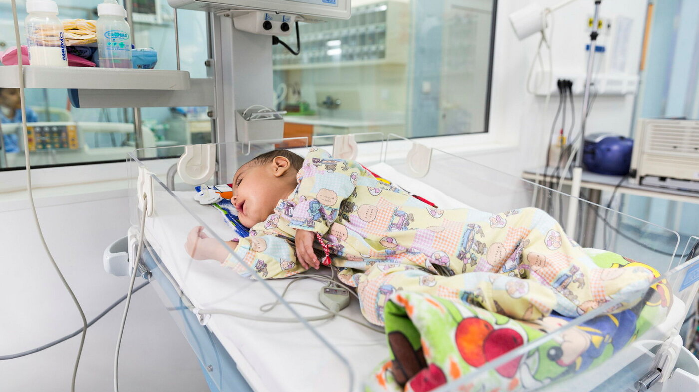Baby på hjerteavdelingen Bildet viser en baby med hjertefeil som ligger i kuvøse på sykehus