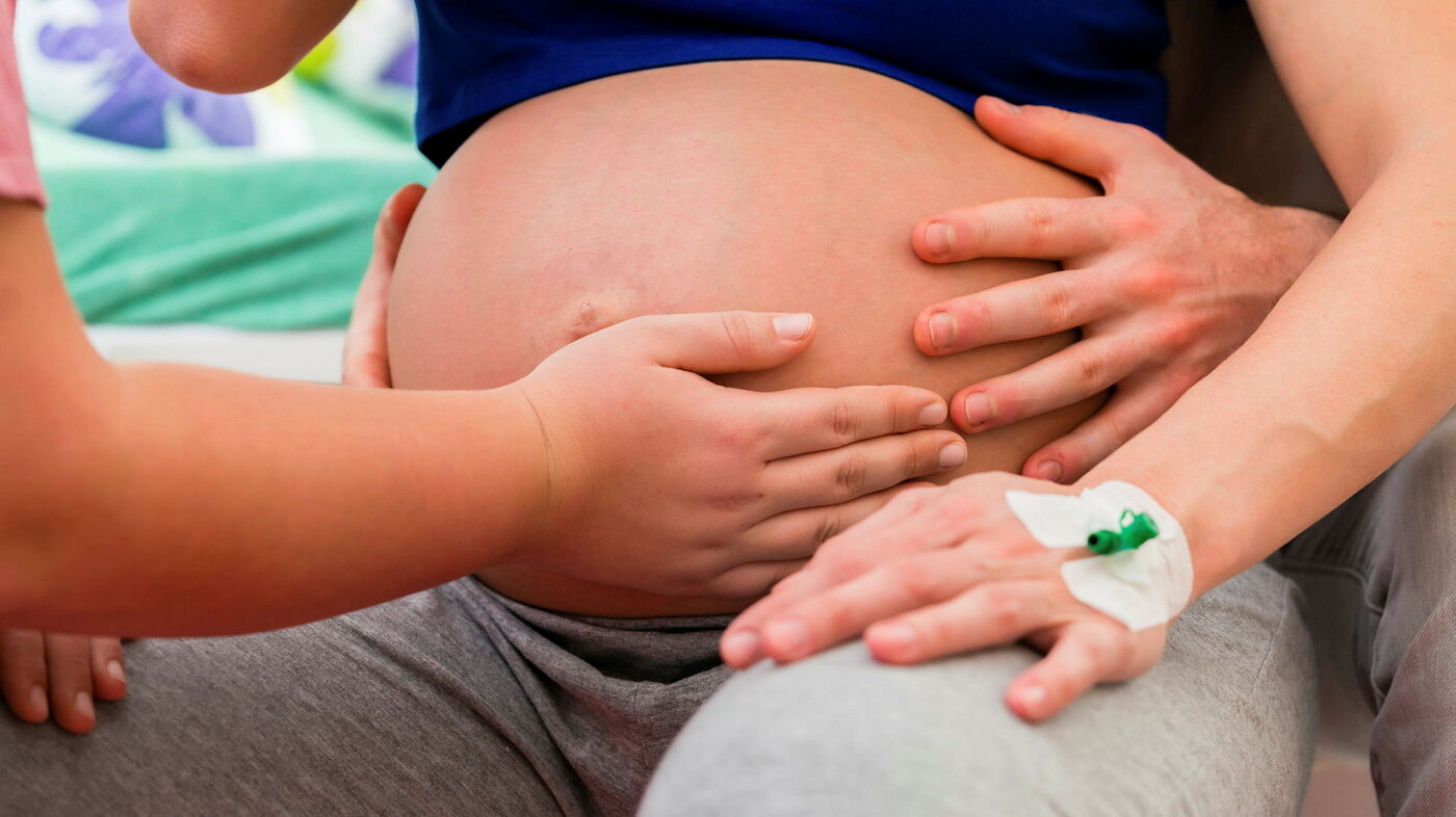 jordmor sykpleier holder på gravid mage