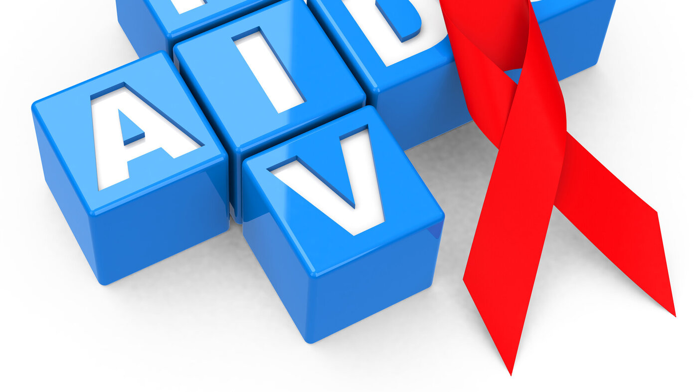 En rød sløyfe ligger oppå bokstavene til hiv/aids. 