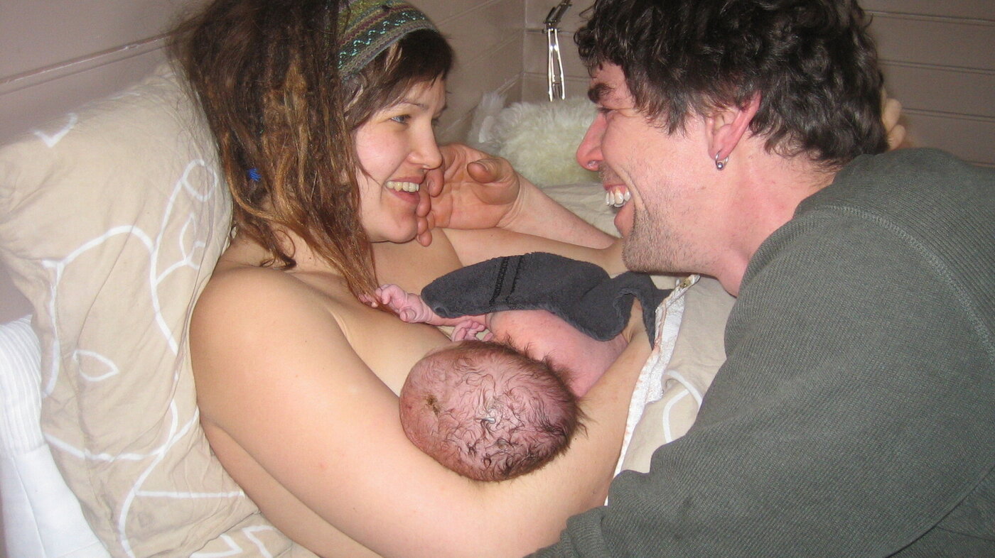 Bildet viser mor, far og nyfødt barn.