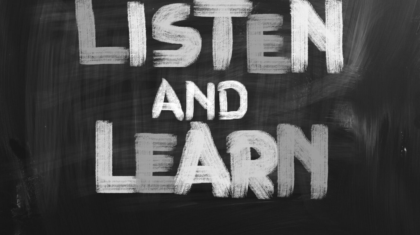 Tavle med teksten "Listen and learn"