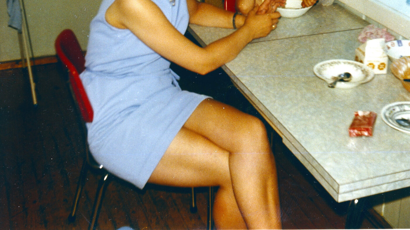 Bildet viser Karin Jonli som barn sammen med moren ved kjøkkenbordet.
