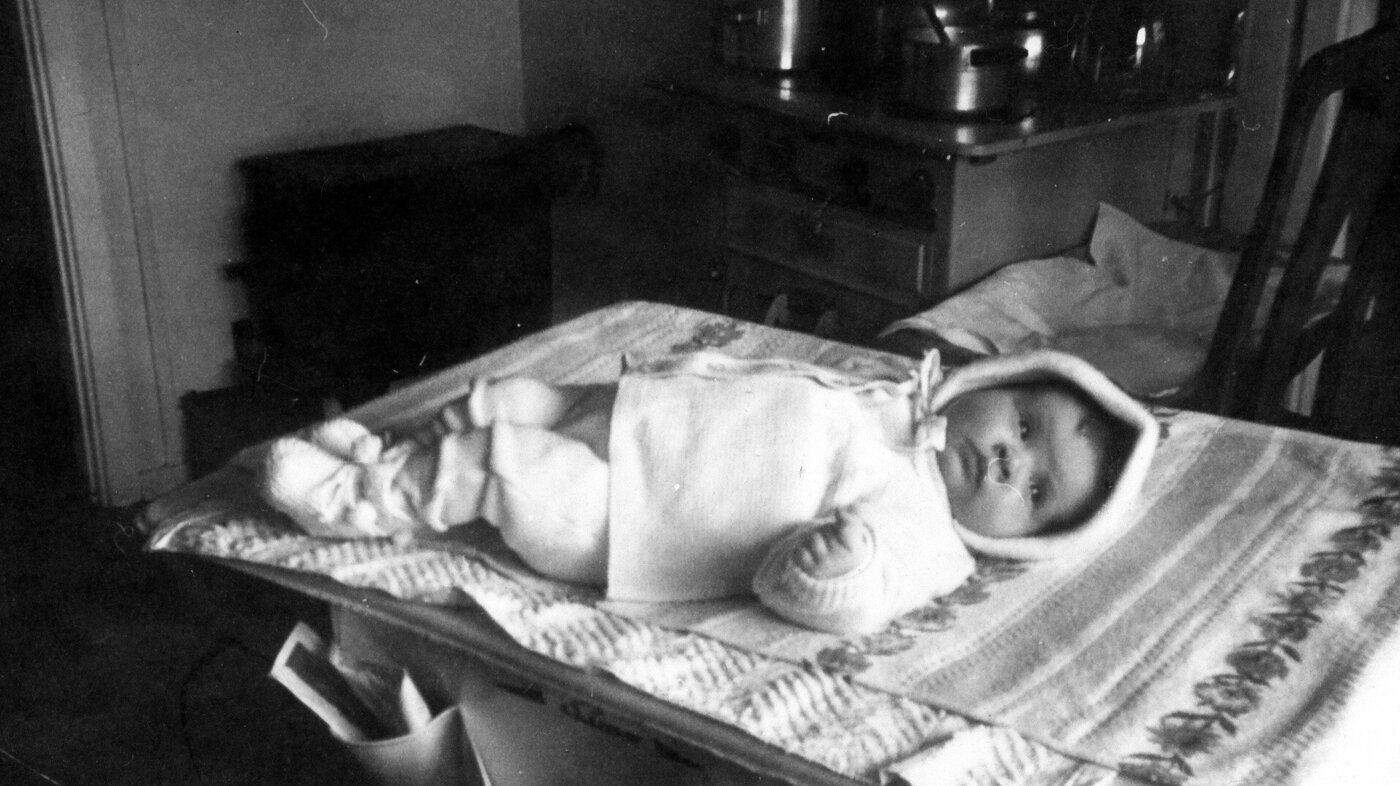 Bildet viser Karin Jonli som baby liggende på et stellebord.