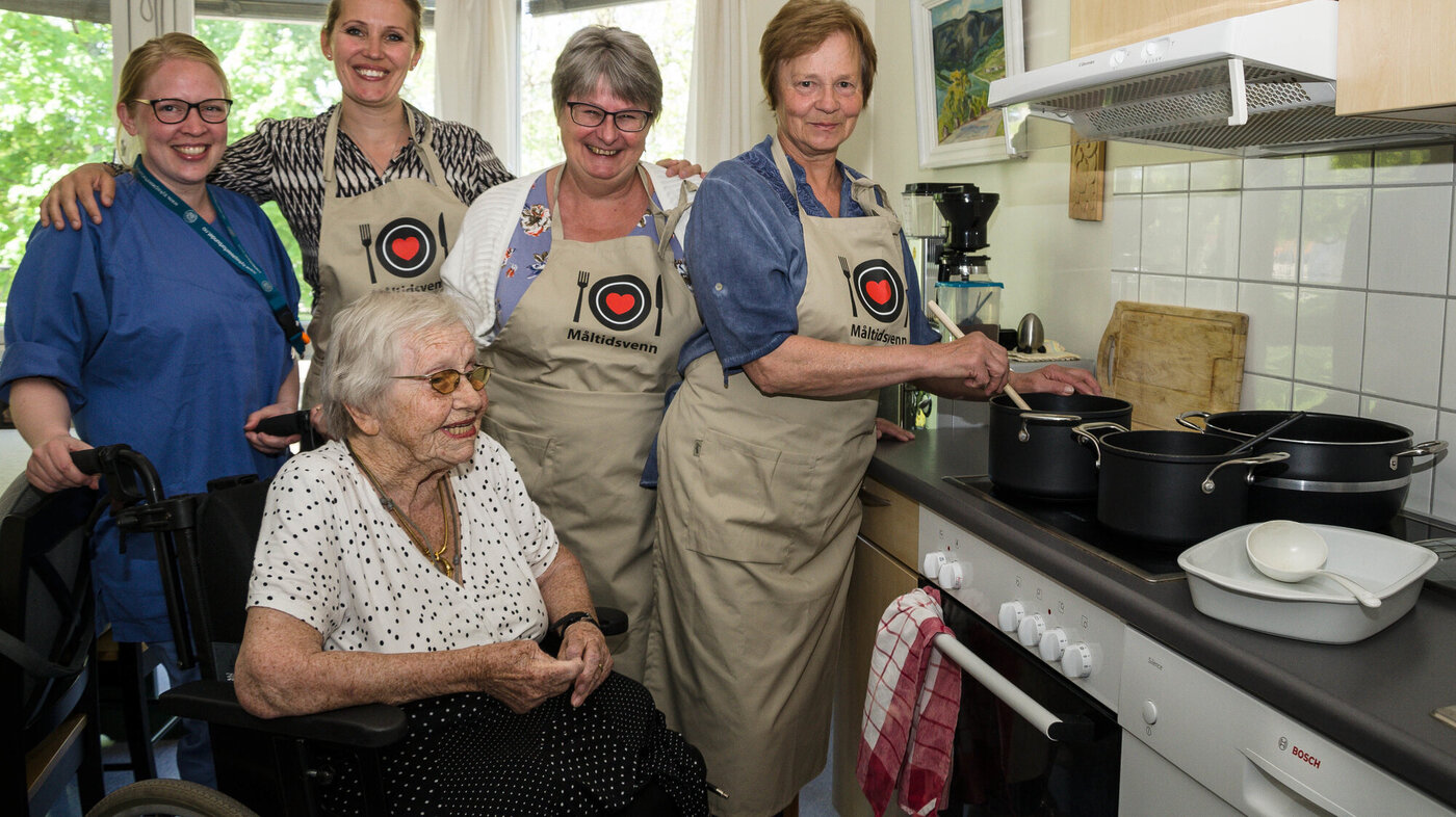 Bildet viser fem kvinner på kjøkkenet.