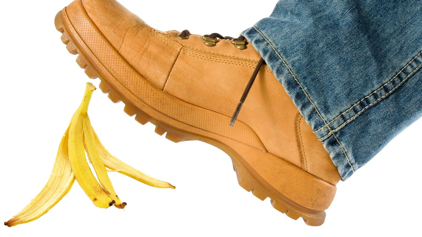 Illustrasjonsbilde av en fot som er i ferd med å skli på et bananskall