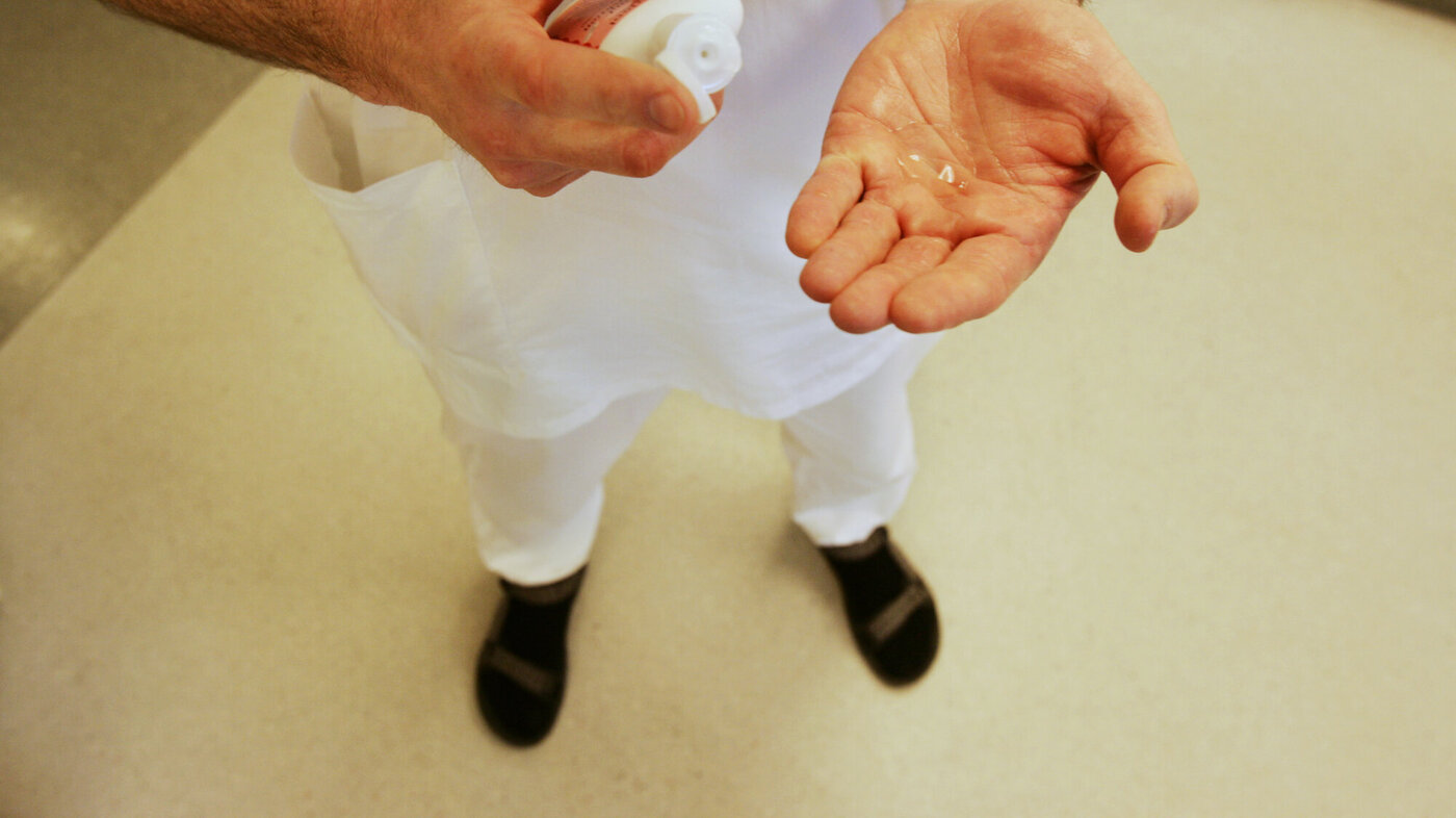 Bildet viser hender som gjør hånddesinfeksjon.