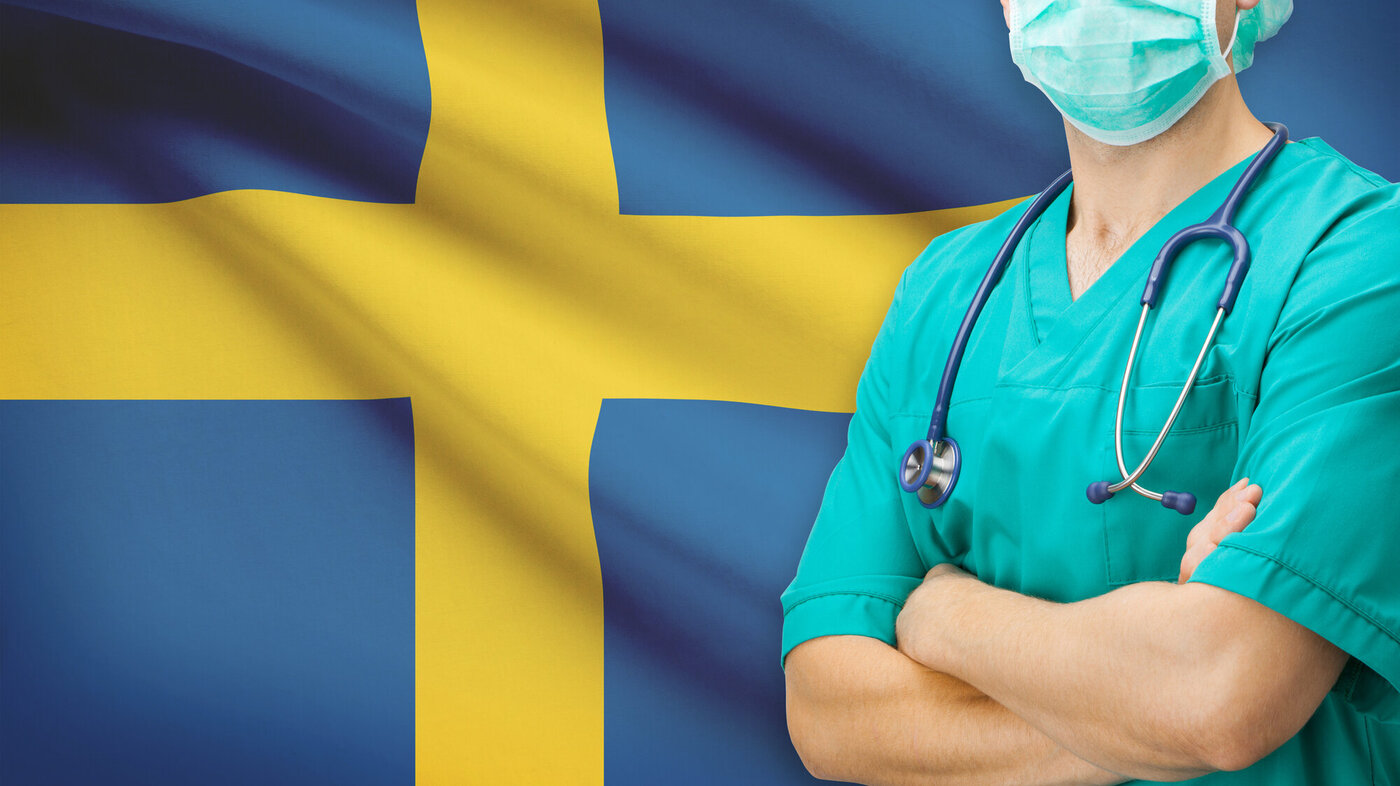 Svensk sykepleier med flagg i bakgrunnen