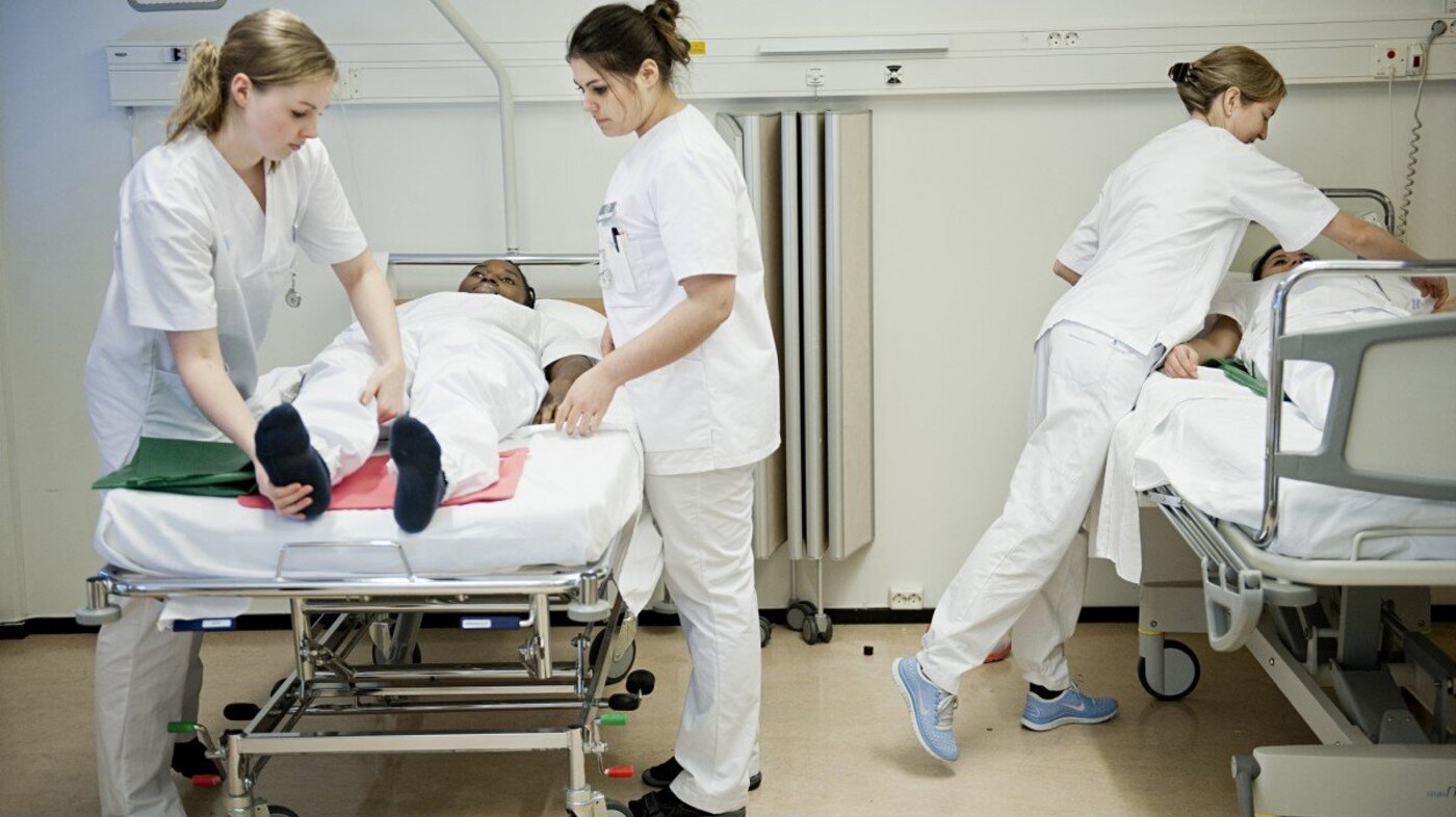 Sykepleiestudenter som øver ved seng.