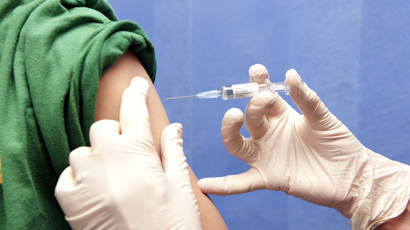 Bildet viser en vaksine som blir satt i en overarm.