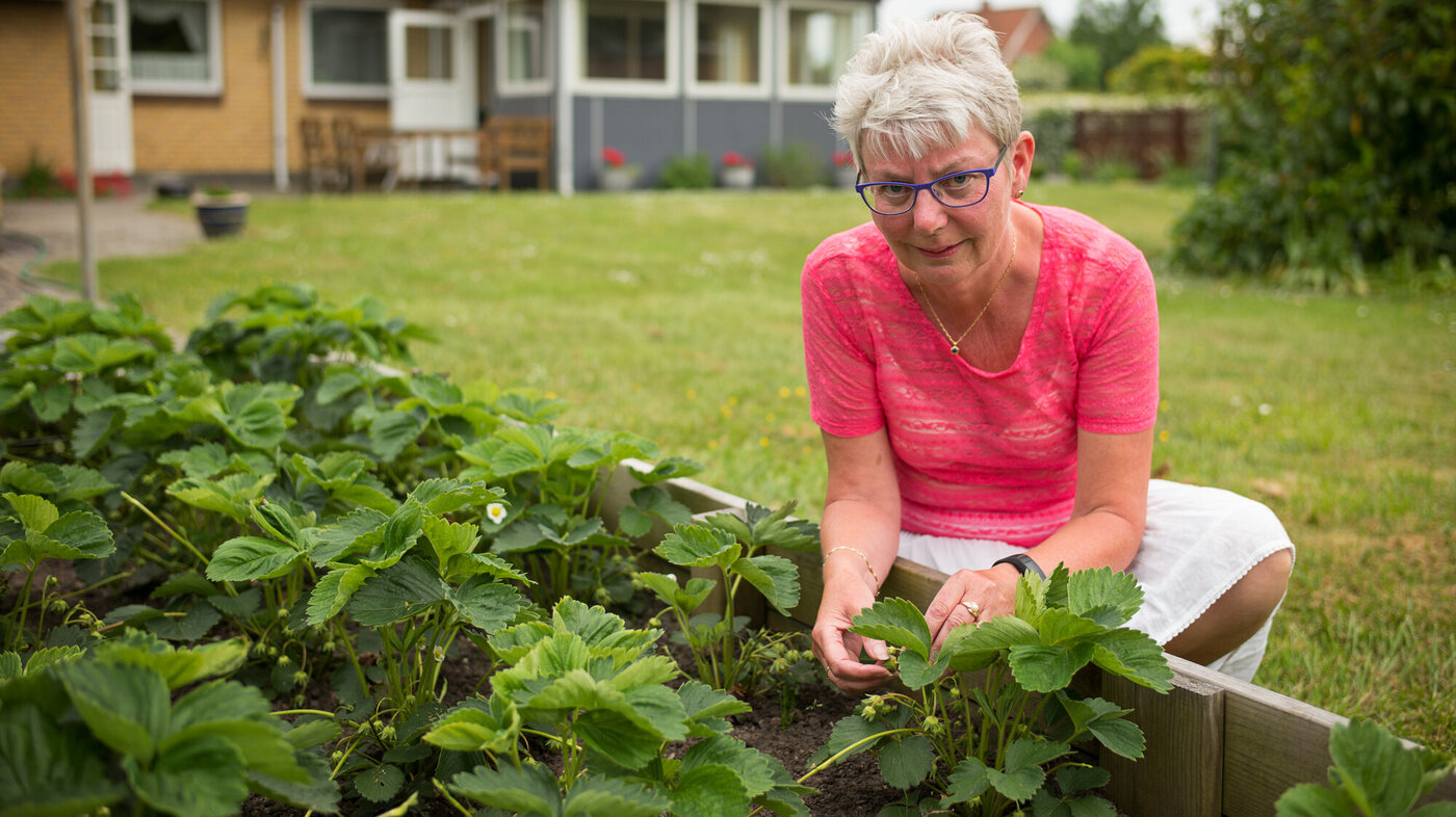 Bildet viser Pia Christensen som gjør hagearbeid.