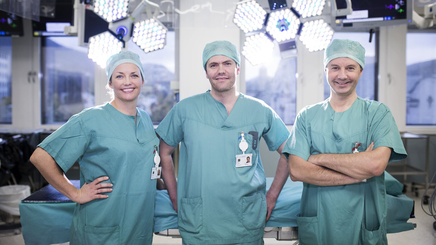 Bildet viser to sykepleiere og en kirurg på operasjonsstuen på Haukeland universitetssjukehus