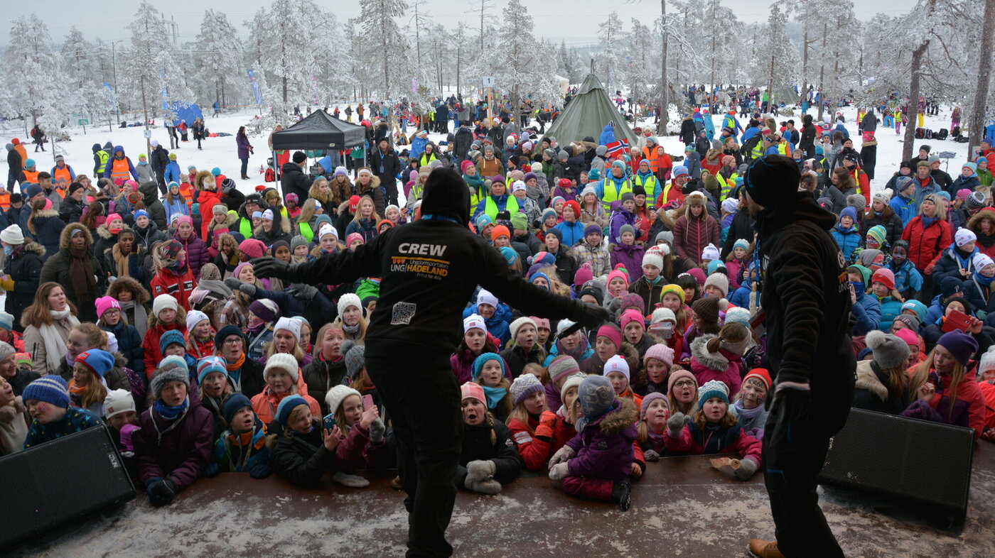 Ski-NM Bildet viser en flokk med ungdommer foran en scene på under ski-NM på Lygna