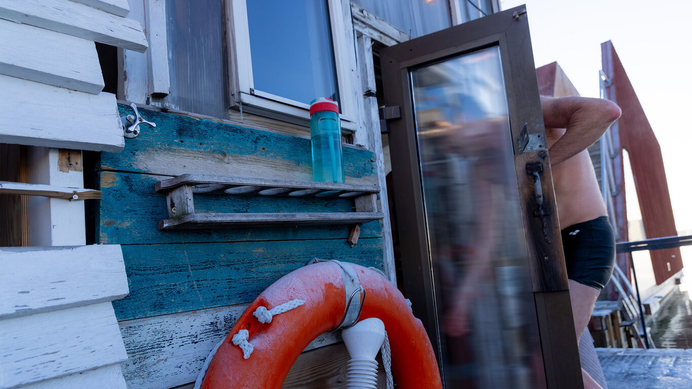 Bilde viser en mann p&aring; vei inn i en badstue