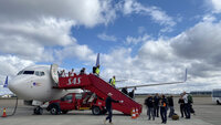 Bildet viser medisinsk innsatsteam på vei ut av et fly.