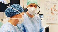 Bildet viser operasjonssykepleier som veileder en operasjonssykepleierstudent.