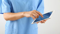 Bildet viser en sykepleier som skriver på en Ipad
