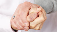 Bildet viser to hender som holder hverandre.