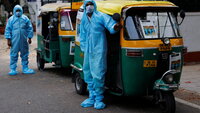 Bildet viser to rickshaw-ambulanser med to sjåfører ikledd smittevernutstyr.