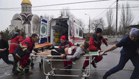 Ambulansepersonell flytter en skadet mann i et boligområde etter bombing i byen Mariupol i Ukraina.