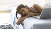 Bildet viser en ung kvinne som ligger på en seng med øynene lukket