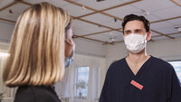 Bildet viser helsepersonell og en pasient iført ansiktsmasker