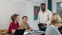 Bildet viser en lærer som diskuterer med tre elever