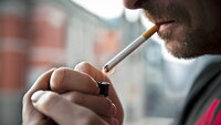 Bilde av mann so tenner sigarett