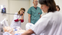 Bildet viser sykepleierstudenter og annet helsepersonell som simulerer pasientsituasjoner med bruk av en dokke.