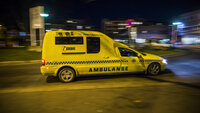 Bildet viser en ambulanse som kjører om kvelden