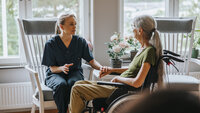 Bildet viser en sykepleier som er hjemme hos en palliativ pasient