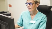 Bilder viser en sykepleier som skriver på en PC