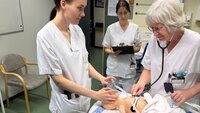 Bildet viser to jordmødre og en barnepleier som trener på nyfødtresuscitering på babydokke