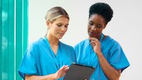 Bildet viser to sykepleiere som bruker en iPad