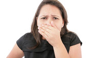 Bildet viser en kvinne som holder seg for nesen og munnen.
