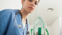Sykepleier holder oksygenmaske.