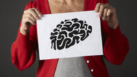 Bildet viser en eldre kvinne som holder opp en tegning av en hjerne.