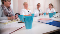 Bildet viser fagfolk fra ulike helseprofesjoner som sitter rundt et bord