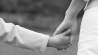 En voksen hånd leier en barnehånd
