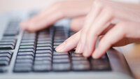 Bildet viser hender som skriver på et tastatur.
