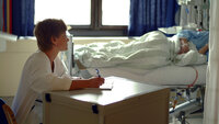 Bildet viser en sykepleier som skriver dagbok for en pasient