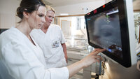 Bildet viser to sykepleiere som ser på monitoren på nyfødtintensiven.