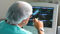 En kirurg sitter og vurderer pasientdata på en dataskjerm