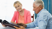 Senior couple looking at photo album in a retirement home