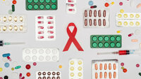 Bildet viser en aidssløyfe omgitt av masse forskjellige typer piller